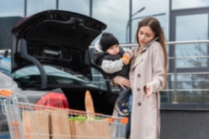 mom son parking lot car open trunk groceries